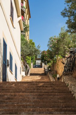 Konforlu, küçük bir sokak, merdivenlerde taş basamaklar, yan taraflarda bisikletler ve çiçek açan çalılar var. Port de Soler, Mollorca Adası, Balearic Adaları, İspanya