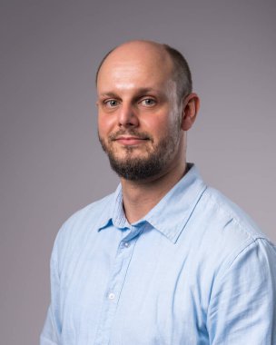 Mavi gömlekli, sakallı 35 yaşında bir adamın portresi. Yakın plan. 