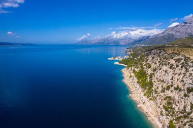 Hava aracı görüntüsü. Hırvatistan 'ın Dalmaçya kentini kuş bakışı gören güzel kıyı şeridi, berrak deniz. Makarska Riviera, Avrupa 'nın ünlü ve turistik mekanı