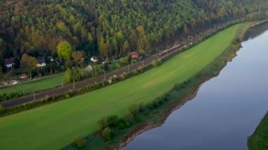 Almanya, Sakson İsviçre 'deki ulusal parkta sabah. Güneş Elbe Nehri 'nin üzerinden doğuyor. Hızlı bir tren geçiyor. Bastei Köprüsü 'nden görüntü. 