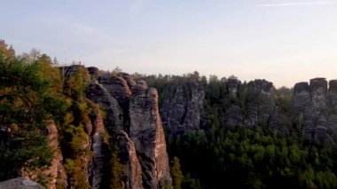 Almanya, Sakson İsviçre 'deki ulusal parkta sabah. Güneş Elbe Nehri 'nin üzerinden doğuyor. Hızlı bir tren geçiyor. Bastei Köprüsü 'nden görüntü