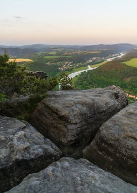 Yeşil çayır ve tarlaları, vadide düzgün evleri ve Elbe Nehri 'nin bulunduğu kırsal bir motifin kayasının güzel manzarası. Ulusal Park Sakson İsviçre, Almanya 