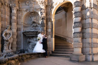 Şirin bir çiftin yakın plan portresi. Gelin ve damat birbirlerinin gözlerinin içine bakıyor. Gelin daha yüksekte duruyor ve damada yukarıdan bakıyor.