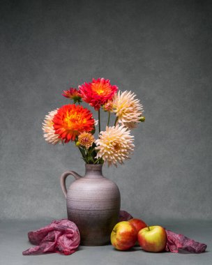 Üzerinde bahçe çiçekleri olan parlak bir buket vazo gri arka planda, yanında üç kırmızı elma yatıyor. Değişik yıldız çiçekleriyle dolu renkli bir sonbahar. Kartpostal, tebrikler, dilekler 