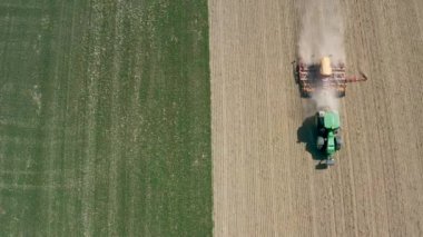 Drone 'un hava görüntüleri: Bir traktör ekin ekmek için tarla sürüyor. Tarım konsepti, tarım ürünleri ekme