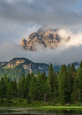 Dolomitlerin inanılmaz resimli dağ manzarası. Drei Zinnen Dağı ya da Tre Cime di Lavaredo yoğun bulutların arasından hafifçe görülebilir. İtalyan Dolomitleri