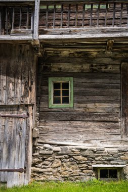 Çok eski bir ahşap ev. Ahşap duvardaki küçük pencere. Eski ahşap bir evin elementleri.