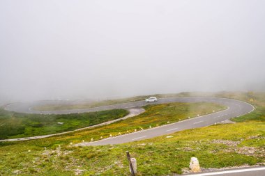 Popüler, dolambaçlı yüksek bir dağ yolu bulutların arasında kayboluyor. Avusturya 'daki Hohe Tauern Ulusal Parkı' ndaki Grossglockner Yüksek Alp Yolu.