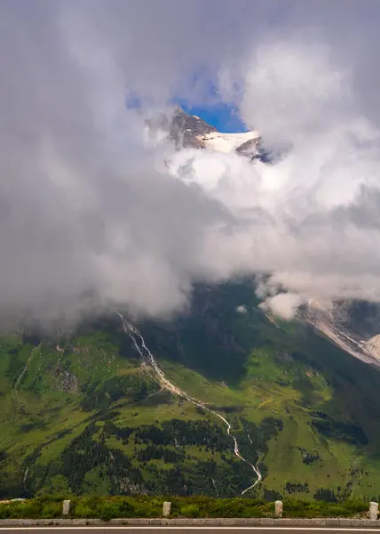 stock image Majestic mountains peeking out through thick clouds. A small piece of blue sky peeking out through clouds. Hohe Tauern. Austria. grossglockner high alpine road