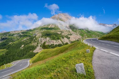 Dönek alp yolu Grossglockner. Güzel dağ manzarası. Bulutlar yüksek kayalıklara iner. Güneşli bir gün. Grossglockner yüksek alp yolu. Hohe Tauern Ulusal Parkı. Avusturya