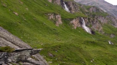 Grossglockner. Hohe Tauern. Avusturya. Yeşil bitkilerle kaplı dağlarda şelale. Popüler Grossglockner yüksek dağlık yolunda. Popüler turizm merkezi