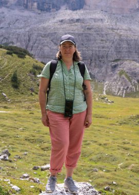 Orta yaşlı kadın blogcu Dolomite Alpleri 'ne doğa güzelliğinin fotoğrafını çekmek ve blogunda paylaşmak için cep telefonuyla yürüyüşe gider.