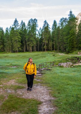 Orta yaşlı aktif bir kadın sırt çantasıyla Alp Dağları, Dolomitler, Güney Tyrol, İtalya 'da yürüyüş yolunda yürüyor. 50 yaşından sonra aktif yaşam tarzı, yürüyüş, seyahat 