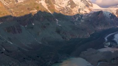 Sabahın erken saatlerinde karlı tepelere güneş doğar. Grossglockner Dağı. Sonsuz Pastertse buzulu. Avusturya.