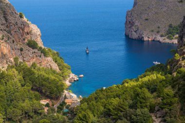 Cala de Sa Calobra 'nın sakin körfezinin mavi suları ve El Turmas sıradağlarıyla çevrili demirlemiş teknelerinin güzel manzarası. Mallorca kıyısı. 