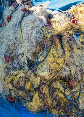 Rıhtımda endüstriyel balıkçı ağları. Mavi arka planda uzanan balık ağları balık yakalamak için gerekli araçlardır.