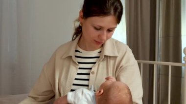  Şefkatli ve sevecen anne yeni doğmuş bebeğinin yüzünü nazikçe dokularla siler. Anne kucağına alır ve bebeğini kucağına alır. Anneler yeni doğan oğlunu sever ve ona bakar. Annelik kavramı. Ebeveynlik. Annelik.