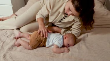 Sevgi dolu anne yeni doğmuş bebeğini nazikçe okşuyor. Bebek karnının üstünde yatar ve tatlı tatlı uykuya dalar. Anneni yeni doğan oğluna sev ve kolla..