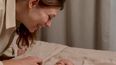 Annelerin elleri nazikçe bebeklerin elini tutar. Yeni doğan bebek annesine bakıyor. Bebek yüzlü kostüm