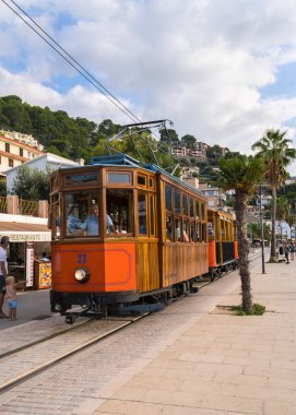 Port de Soller. Mallorca. İspanya. 4.10.2023. Ünlü turuncu tramvay Soller 'dan Port de Soller' a gidiyor. Güneşli bir gün, bir sürü turist 