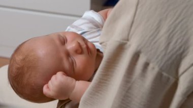 Yeni doğan bebek annesinin kollarında uyur. Bebeklerin yüzüne yakın çekim