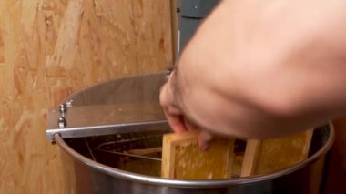 Erkekler çerçeveleri altın balla doldurup bal kavanozuna koyarlar. Arıcı cintrifüj 'ü açıyor. Ballı çerçeveler taze organik ürün üretmek için makinede döner