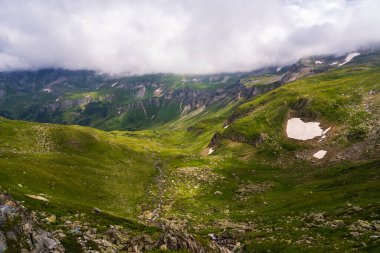 Summer panorama of Alpine Alps. Remnant of snow in valley. Picturesque view from Grossglockner High Alpine Road. Austria. clipart