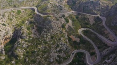 Dağlarda virajlı yılan yolu. Hava aracı görüntüleri Sa Calobra. Motosiklet için ünlü bir yarış pisti, bisikletçi. 4 