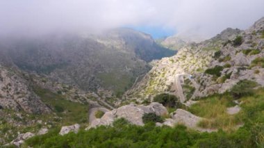 Sa Colabra, Mallorca dağlarındaki yılan yolunun insansız hava aracı videosu. Araba, otobüs, bisikletçi yavaşça tırman.. 