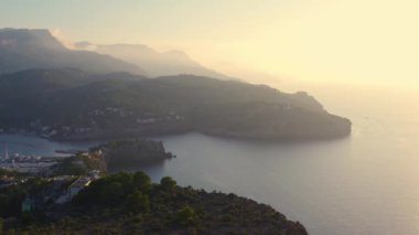 Akşam kasabası Port de Soller 'in hava manzarası. Yat ve tekne suda sallanıyor, gün batımı ışığıyla dolup taşıyor. Dağın etrafinda, rıhtım. Mallorca. İspanya