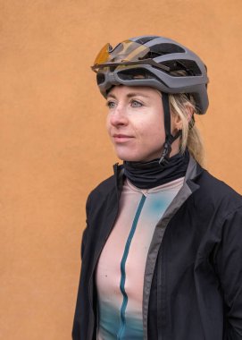 Closeup portrait female cyclist in helmet and cycling outfit in profile . Cyclist after training. Face and clothes in drops dirt clipart