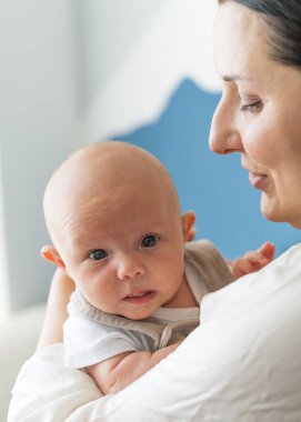 Anne şefkatle ve sevgiyle kucağında yeni doğmuş bebeğini tutuyor. Bebek yüzünü kapat.
