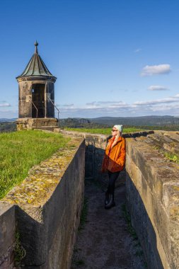 girl with bandage on her arm, after an injury, enjoys rehabilitation in nature. Visits beautiful places despite injury. Rehabilitation period after surgery. Taking care health. Koenigstein. Germany clipart