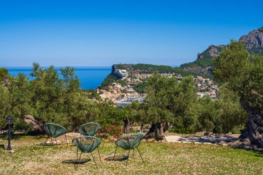 İspanya 'nın Akdeniz kıyılarının güzel manzarası. Mallorca. Balear Adaları. Turistler için rahat bir kafede ön planda rahat sandalyeler.