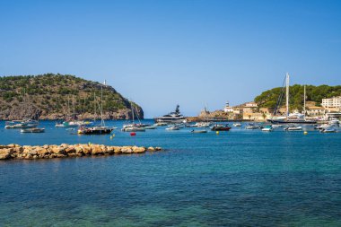 Port de Soller 'in güzel sahil manzaralı turistik kasabası. Demirlemiş yatlar, limandaki gemiler. Rocky Coast, deniz feneri. Mallorca, İspanya. Balear Adaları