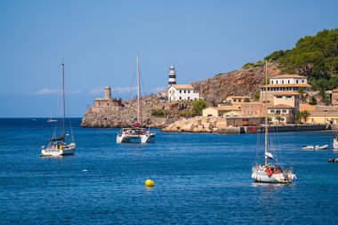Port de Soller 'daki küçük bir deniz fenerinin resimli görüntüsü. Demirlemiş yatlar, limandaki gemiler. Mallorca, İspanya