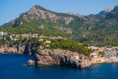 Turkuaz deniz suları, güzel turistik kasaba Port de Soller 'in görkemli kayalıklarına çarpıyor. Akdeniz güzeli. Mallorca. İspanya. Balear Adaları.