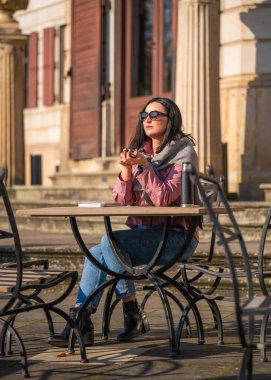 Caddedeki kafede oturup kitap okuyan çekici bir kadın, onun yanında termos var. Temiz havada kendi kendine eğitim. Günlük girdileri. Boş zaman. Tatil, hafta sonları.