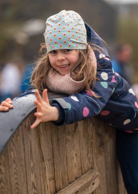 Serin mevsimde açık bir parkta aktif olarak oynayan bir kız. Boş zaman. Çocukluk.