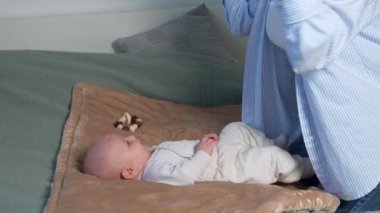  Yenidoğan yatakta yatıyor, anne bebekle konuşuyor, bebeğe öğretiyor. Çocuk sesleri tekrarlamaya çalışıyor. Çocuk gelişimi. Annelik. Doğum izni.