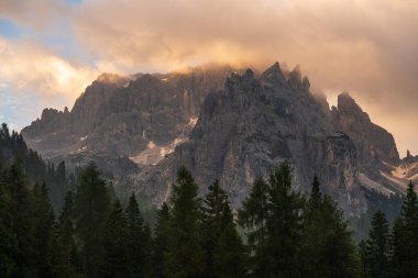 Gün batımında dağlar. Görkemli kayalık tepeler, yumuşak altın gün batımı ışığıyla aydınlanır. Dolomit Alpleri, İtalya. Popüler turizm merkezi.