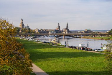 Dresden, Saksonya, Almanya. 19.10.2024. Dresden, Almanya. Eski şehrin tarihi merkezi Elbe nehrinin güzel manzarası. Turistler rıhtımda duruyor ve eğlence teknesini bekliyorlar..