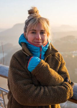 Sıcak elbiseli turist kız gün batımında İsviçre 'de Sakson Köprüsü' nde duruyor ve Elbe Nehri 'nin görkemli uçurumlarının keyfini çıkarıyor. Popüler turizm merkezi. Almanya.