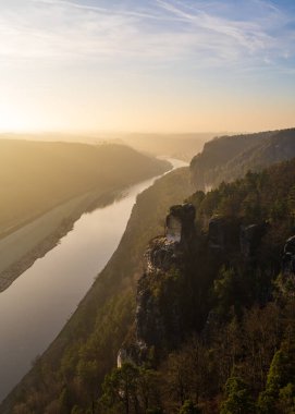 Almanya 'da Sakson İsviçre' nin kış günbatımı manzarası ve Bastei Köprüsü 'nün yüksekliğinden manzara. Elbe Nehri 'ndeki kum taşı dağları. Popüler turizm merkezi.