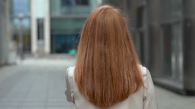 Uzun kızıl saçlı güzel bir kız tatlı tatlı başını kameraya çevirir. Yüz ifadesi şefkat ve dostluk yayar. İçerik: güzellik, duygular, doğallık