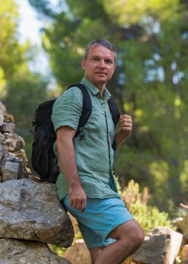 Sırt çantalı orta yaşlı bir adam Mallorca 'nın manzaralı bölgelerinde geziyor, doğanın tadını çıkarıyor. Hayat tarzı macera konsepti yaz tatili yalnız başına. Yürüyüş, turizm, seyahat..