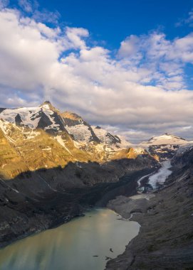 Görkemli Grossglockner dağı ve Pastertse buzulu güneşin ilk ışıklarıyla kutsanmıştır. Dağ tepeleri karla kaplı. Doğanın güzelliği