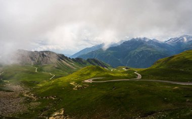 Avusturya 'daki ünlü yüksek dağ yolunun nefes kesici manzarası Grossglockner hochalpenstrasse. Virajlı yollar dağ geçitleri boyunca uzanıyor. Yol gezileri, bisiklet sürmek ve doğanın tadını çıkarmak için ideal bir yer.