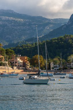 Port de Soller 'in pitoresk limanına demirlemiş zarif yatlar, sakin turkuaz suları yansıtıyor. İspanya, Balear Adaları