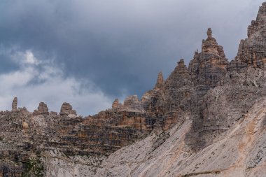 Sharp and towering rock peaks Dolomites rise dramatically against sky, showcasing raw beauty of this iconic mountain range. Breathtaking display of natures power and geological wonder clipart